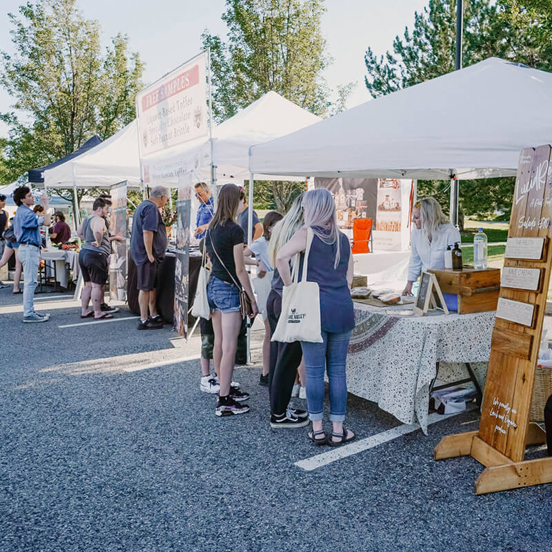 A group of people at an outdoor farmers market.