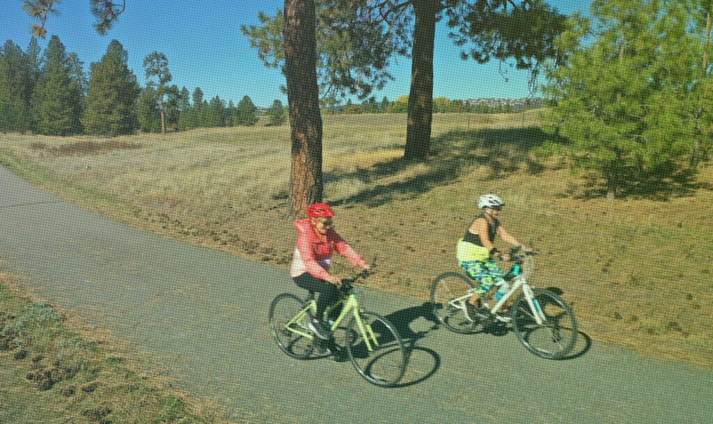 Two women cycling on the Centennial Trail.