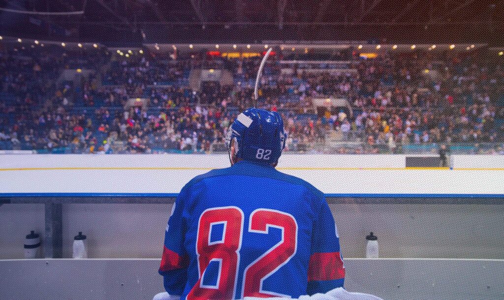 Hockey player waiting on the sidelines.