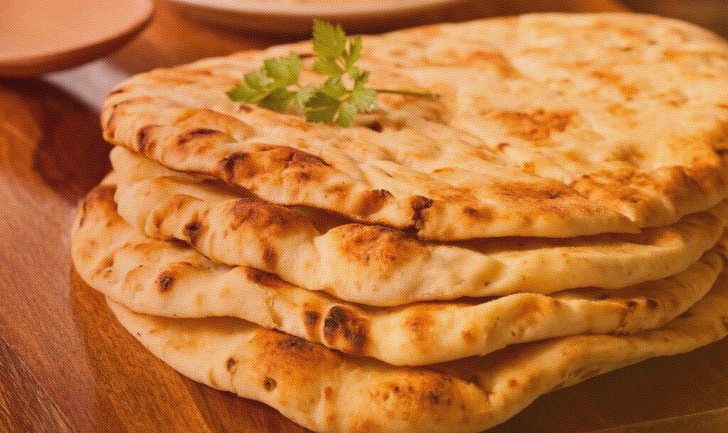 Stack of lightly toasted naan bread with garnish.